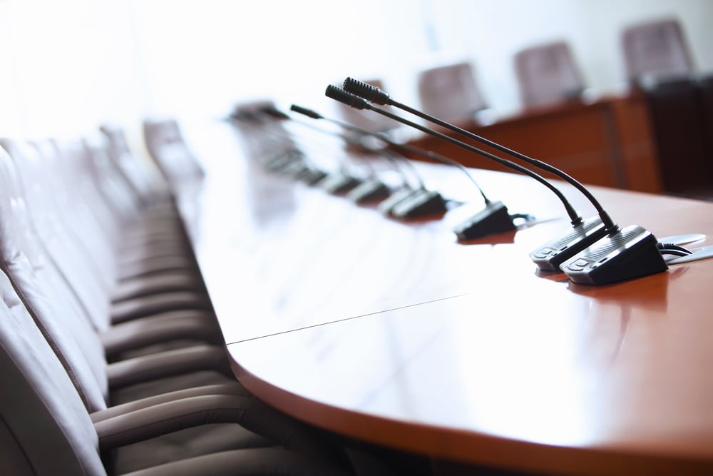 before a conference, the microphones in front of empty chairs.